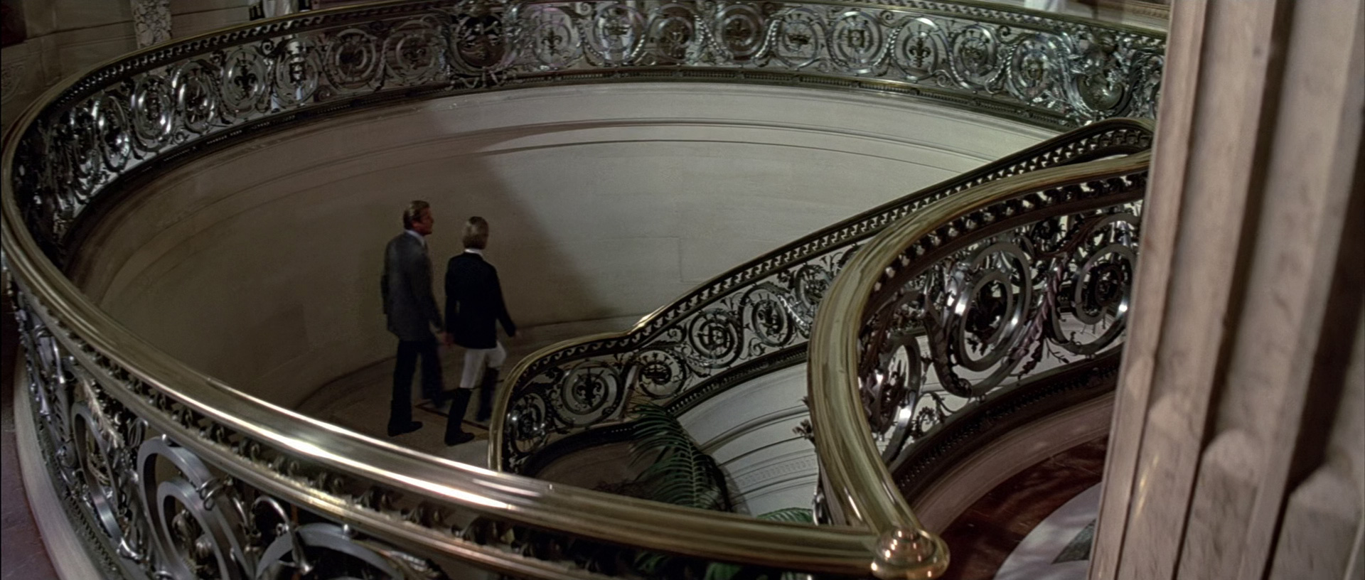 Bond and Jenny walk up the staircase
